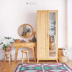 a room with a mirror, table and stools on the wooden floor next to it