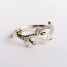 "From our BACK TO NATURE Collection... 14K gold budded twig ring produced by using traditional goldsmithing techniques. Buds are made from 14k solid gold and soldered to the sterling silver twig band one by one. Pattern on twig is also made by hand which makes each ring unique. **Details** ✪ Material: Buds: 14k Solid Gold Twig Band: Sterling Silver **Please be aware that the twig may get tarnished over time as it is a natural reaction for sterling silver. You may clean it with a plain, solid-colored toothpaste (not gel) with no baking soda, tartar control, or whitening agents. Just apply a small amount of toothpaste to the twig, brush with a toothbrush and rinse.  Please carefully select your ring size from the drop-down menu. We use standard US ring sizing but can find out your size in an Raw Rings, Twig Jewelry, Measuring Scale, Romantic Nature, Wax Ring, Twig Ring, Branch Ring, Future Engagement Rings, Carved Ring