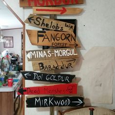 there are many wooden signs on the wall in this kitchen that read mordor, shelo's inn, fancorn, minas - morgru, des - morgul, dol, del glarr