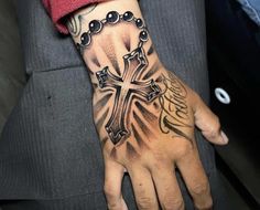 a person with a cross tattoo on their hand