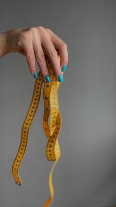 a woman's hand holding a measuring tape