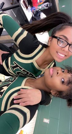 two women in matching outfits posing for the camera