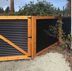 a gate that is made out of metal and wood, with a wooden slatted design