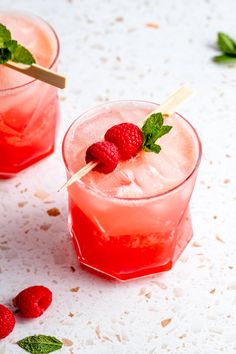 two glasses filled with raspberry lemonade and garnished with mint leaves