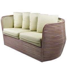 an outdoor sofa with four pillows on it's back and sides, all in wicker