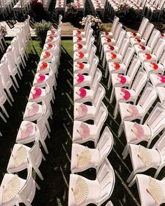 rows of white chairs with pink and red decorations