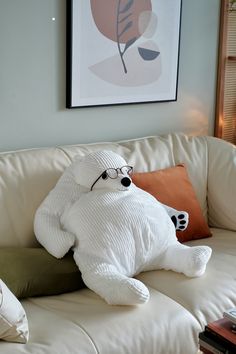 a white teddy bear sitting on top of a couch