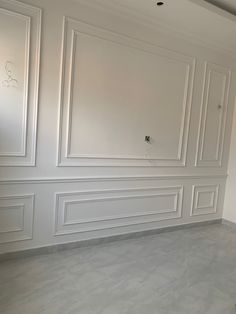 an empty room with white walls and paneling