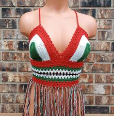 a mannequin wearing a red, white and green crochet top with fringes