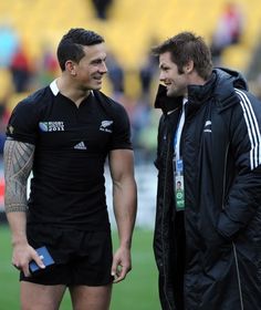 two rugby players are talking on the field