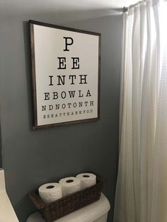 a white toilet sitting under a framed eye chart