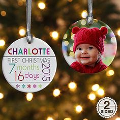 two personalized christmas ornament hanging from a tree with lights in the background