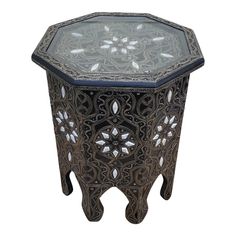 an intricately designed side table with glass top