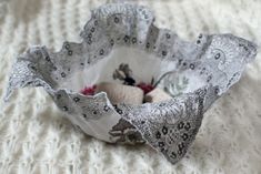 a decorative bowl is sitting on a white blanket