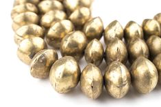 several brass colored beads on a white background