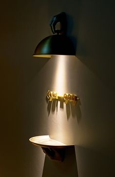 a lamp that is on the side of a wall next to a shelf with letters