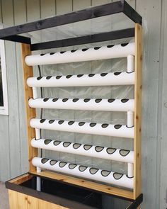 a large wooden rack with many white pipes attached to it