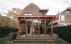 a brick house with glass doors and steps leading up to the front door