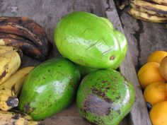 there are many different types of fruit on this wooden table, including bananas and oranges