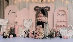 a pink and black cat themed birthday party with balloons, decorations, and decorating