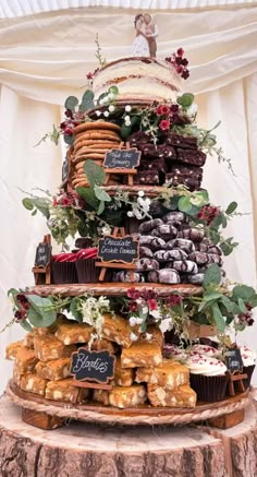 a wedding cake made out of cupcakes and pastries on a tree stump