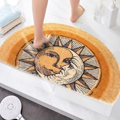 a person standing in front of a door mat with the sun and moon on it