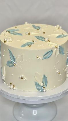 a white cake with blue and gold decorations