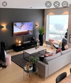 a living room filled with furniture and a flat screen tv mounted to the side of a wall