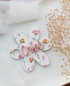 a paper flower with the word love spelled in pink and yellow flowers next to it