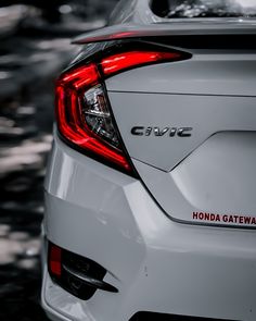 the back end of a white car with red lettering on it