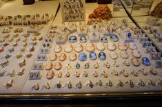 an assortment of jewelry on display in a glass case