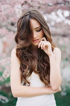 a woman with long brown hair wearing a white dress