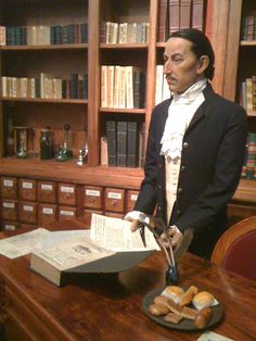 a statue of abraham lincoln is on display in the library with books and pastries