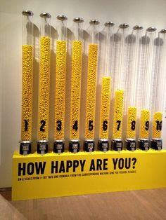 a bunch of cans with numbers on them sitting in front of a sign that says how happy are you?