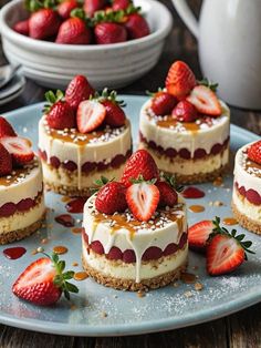 several desserts are arranged on a blue plate with strawberries and other food items