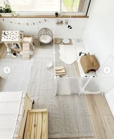 an aerial view of a living room and bedroom area with wood flooring, white walls and windows