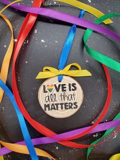 an ornament with the words love is all that matters on it surrounded by colorful streamers