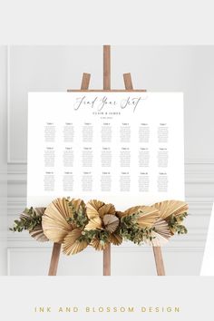 a wedding seating chart with flowers and greenery on the easel for an event