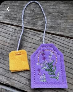 two small tags with flowers on them sitting on a wooden table next to each other