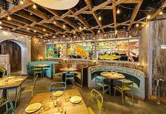 the interior of a restaurant with wooden tables and green chairs, stained glass windows, and wood beams