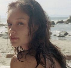 two beautiful young women standing next to each other near the ocean on a sunny day