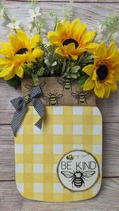 sunflowers in a mason jar with the words be kind written on it and a bee sticker