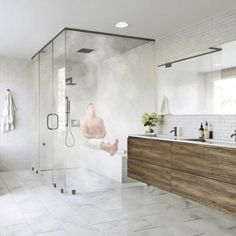 a large bathroom with white tile and wood accents, including a walk - in shower