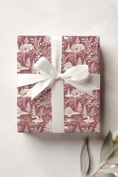 a present wrapped in red and white paper with a bow