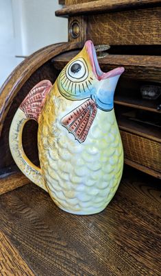 a ceramic bird sitting on top of a wooden shelf