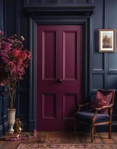 a purple door in a blue room with a chair and vase filled with flowers next to it