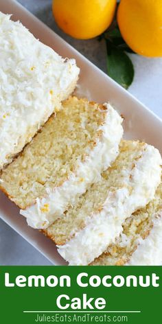 lemon coconut cake with white frosting on a plate next to oranges and green leaves