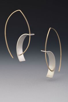 Tension Earring by Hilary Hachey. The convex earwire combined with the concave element create the tension for which this earring is named. The element is sterling silver, and it is available with a matte finish or an oxidized one. The ear wire shown is 18k yellow gold. Modern Oval Earrings With Ear Wire, Modern Metal Hoop Earrings With Oxidized Finish, Modern Oxidized Metal Hoop Earrings, Modern Small Hoop Wrap Earrings With Ear Wire, Modern Hand Forged Drop Earrings, Modern Yellow Gold Wrap Earrings With Ear Wire, Modern Yellow Gold Wrap Earrings, Modern Sculptural Jewelry, Modern Hand Forged Hoop Earrings