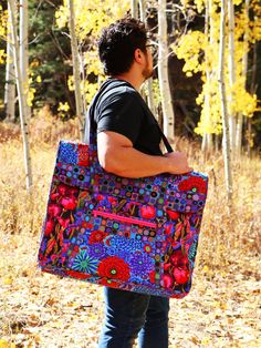 a man carrying a colorful bag in the woods