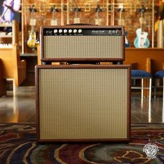 two amps sitting on top of a rug in a room